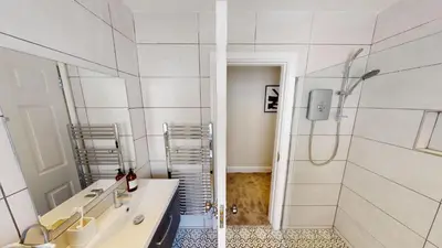 a white bathroom with a shower and a sink at Cathedral Views Heart of City Communal Laundry in Liverpool