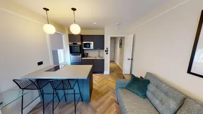 a kitchen and a living room with a couch and a table at Cathedral Views Heart of City Communal Laundry in Liverpool