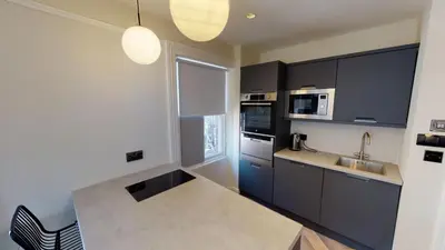 a kitchen with black cabinets and a sink and a window at Cathedral Views Heart of City Communal Laundry in Liverpool