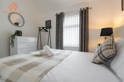 a bedroom with a white bed with a window at 9 Guests, 4 Bedrooms, Modern Comfort in Bootle in Litherland