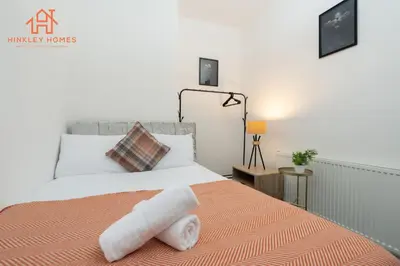 a bedroom with a bed with two towels on it at 9 Guests, 4 Bedrooms, Modern Comfort in Bootle in Litherland