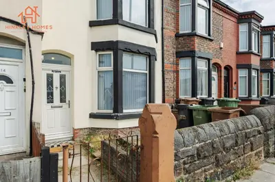 a brick building with a gate and a fence at 9 Guests, 4 Bedrooms, Modern Comfort in Bootle in Litherland