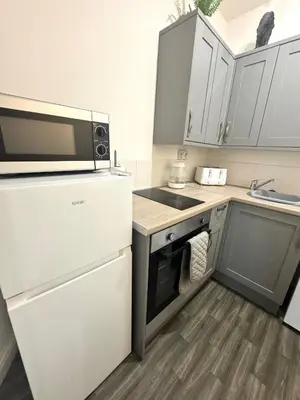 a small kitchen with a microwave and a refrigerator at The Valley View Apartment in Great Harwood