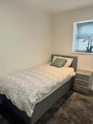 a white bedroom with a bed and a window at The Valley View Apartment in Great Harwood