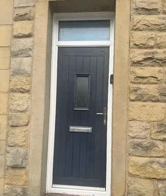 a black door with a window on a brick house at The Valley View Apartment in Great Harwood
