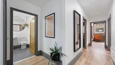 a hallway with white walls and a bathroom with a toilet at Stylish Baltic Apt II, Parking, Sleeps 6! in Liverpool
