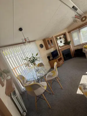 a living room with a glass table and chairs at Lake District Caravan Holiday in Millom