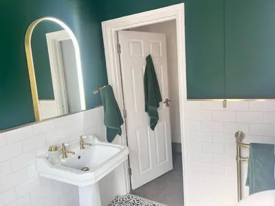 a bathroom with a white sink and a mirror at Historic 1600’s The Grocer’s Cottage in Heysham