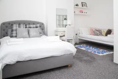 a bedroom with a large bed and a couch at Santiago 3 in Southport