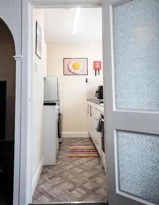 a kitchen with a white refrigerator and a sink at St Andrews by Guestz in Lytham St Annes