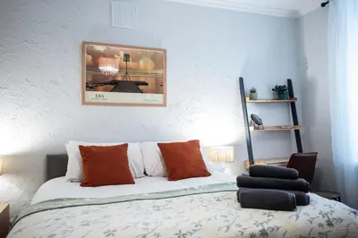 a bedroom with a bed with orange and white pillows at St Andrews by Guestz in Lytham St Annes