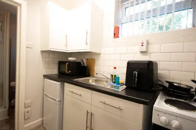 a small kitchen with a sink and a microwave at St Andrews by Guestz in Lytham St Annes