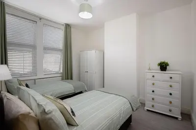 a bedroom with two twin beds and a dresser at Comfy 3-Bed, Sleeps 5 & Parking in Blackpool