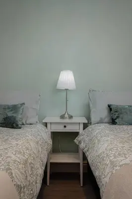 a bedroom with two beds and a table with a lamp at Comfy 3-Bed, Sleeps 5 & Parking in Blackpool