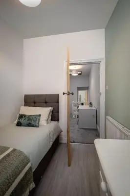 a small bedroom with a bed and a bathroom at Comfy 3-Bed, Sleeps 5 & Parking in Blackpool