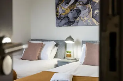 two beds sitting next to each other in a bedroom at Sutcliffe House - Air Host & Stay - 3 bed 3 bath - Contractor Friendly in Liverpool