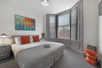 a bedroom with a bed and a large window at Sutcliffe House - Air Host & Stay - 3 bed 3 bath - Contractor Friendly in Liverpool