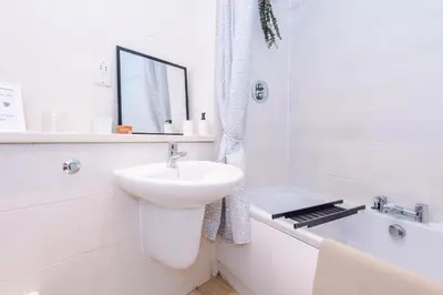 a white bathroom with a sink and a bath tub at Pool Table, Stunning 2Bed Apt, Central Location in Liverpool