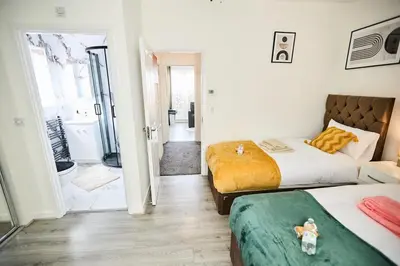 a bedroom with two beds and a bathroom at Ampee Guest Suite-Free Parking in Liverpool