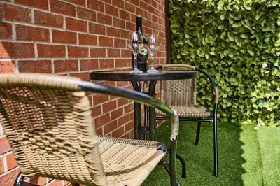 a table with two chairs and a bottle of wine at Ampee Guest Suite-Free Parking in Liverpool