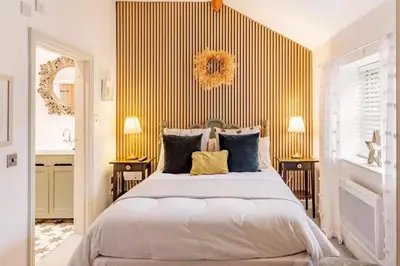 a bedroom with a large bed with yellow stripes at The Lodge at Greenbank Farm