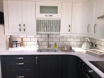 a kitchen with white cabinets and a sink at The Lodge at Greenbank Farm