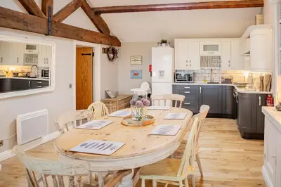 a kitchen and dining room with a table and chairs at The Lodge at Greenbank Farm