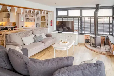 a living room with a couch and a fireplace at The Lodge at Greenbank Farm