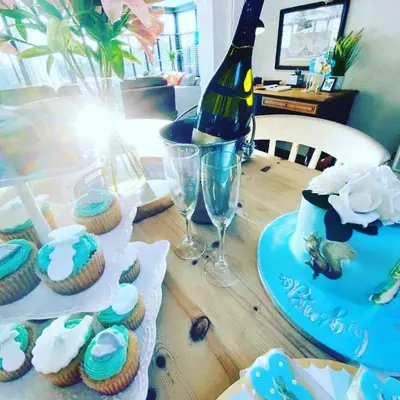 a table topped with cupcakes and a bottle of wine at The Lodge at Greenbank Farm