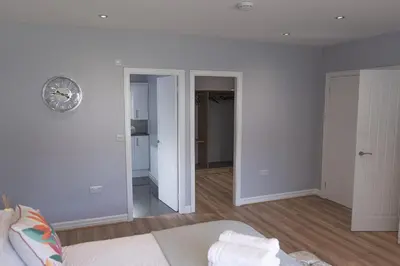 a white room with a clock on the wall at Finsters Retreat in Ainsdale
