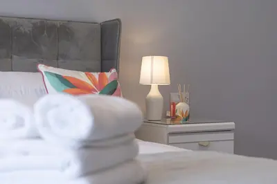 a bedroom with a bed with a lamp and a pillow at Finsters Retreat in Ainsdale
