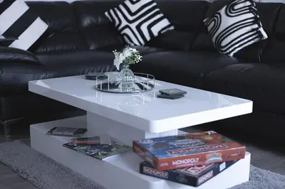 a white coffee table with books and a black couch at Finsters Retreat in Ainsdale