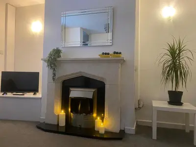 a living room with a fireplace with a mirror at Angies 2 bed home in Eccleston near Liverpool sleeps 5 in Eccleston