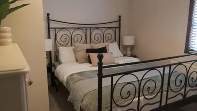 a bedroom with a black and white bed with pillows at 1 Top Locks Cottage in Burscough