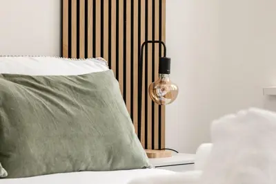 a lamp on a table next to a bed with a pillow at Comfortable Apartment In The Centre Of Preston in Preston