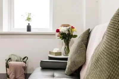 a vase of flowers sitting on top of a couch at Comfortable Apartment In The Centre Of Preston in Preston