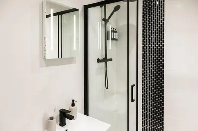 a white bathroom with a shower and a sink at Comfortable Apartment In The Centre Of Preston in Preston