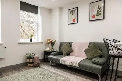 a living room with a green couch and a window at Comfortable Apartment In The Centre Of Preston in Preston