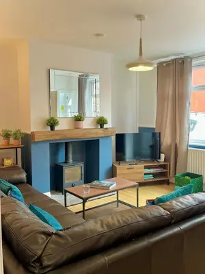 a living room with a couch and a fireplace at Your ideal 3-bedroom home to stay in Leyland in Leyland