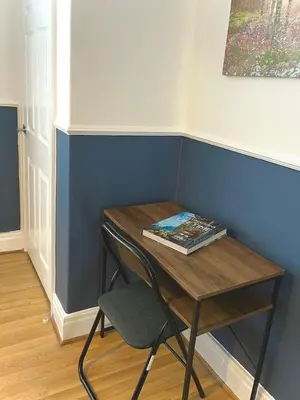 a small table with a chair and a book on it at Your ideal 3-bedroom home to stay in Leyland in Leyland