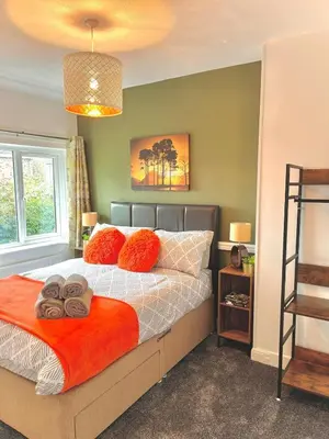a bedroom with a bed with orange pillows at Your ideal 3-bedroom home to stay in Leyland in Leyland