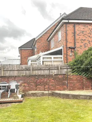 a brick house with a fence and a yard at Your ideal 3-bedroom home to stay in Leyland in Leyland