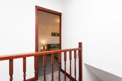 a stairway with a mirror in a white wall at Preston 4 bedroom house near M55 & M6 in Woodplumpton