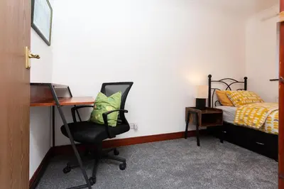 a bedroom with a desk and a bed and a chair at Preston 4 bedroom house near M55 & M6 in Woodplumpton