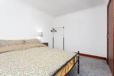 a bedroom with a bed and a white wall at Preston 4 bedroom house near M55 & M6 in Woodplumpton