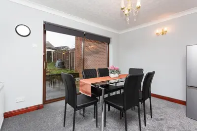 a dining room with a table and black chairs at Preston 4 bedroom house near M55 & M6 in Woodplumpton
