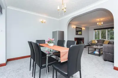 a dining room with a table and black chairs at Preston 4 bedroom house near M55 & M6 in Woodplumpton