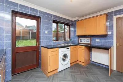 a blue tiled kitchen with a washing machine in it at Preston 4 bedroom house near M55 & M6 in Woodplumpton