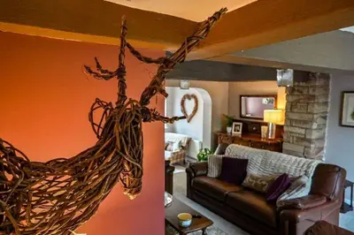 a living room with a couch and a living room with a tree at Beautiful apartment at field view cottage in Eccleston
