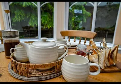 a table topped with white cups and plates on a table at Beautiful apartment at field view cottage in Eccleston